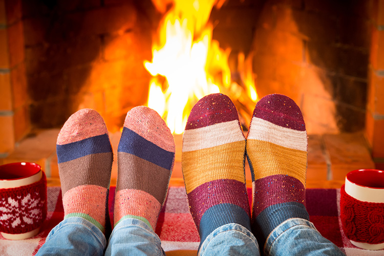 Füße werden am Kaminfeuer gewärmt