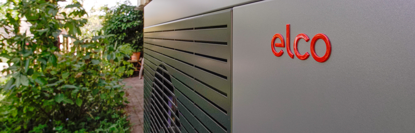 Die Luft-Wasser Wärmepumpe AEROTOP SPK ist vor einem renovierten Haus installiert.