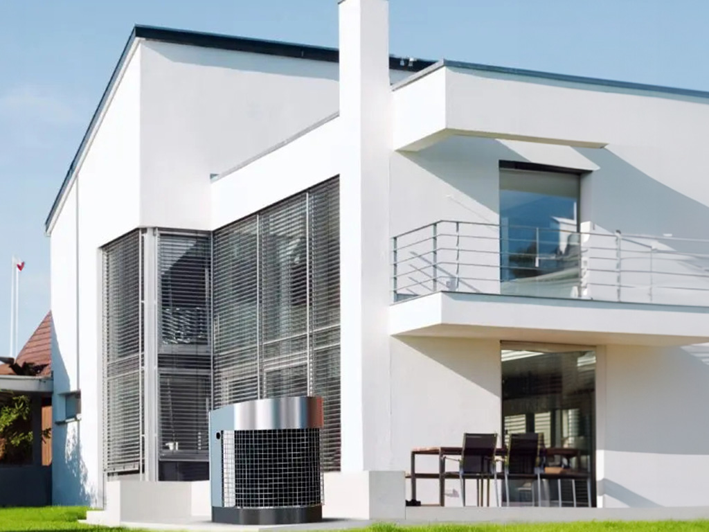 Modernes zweistöckiges Haus mit großem Fenster und aufgestellter Wärmepumpe im Garten